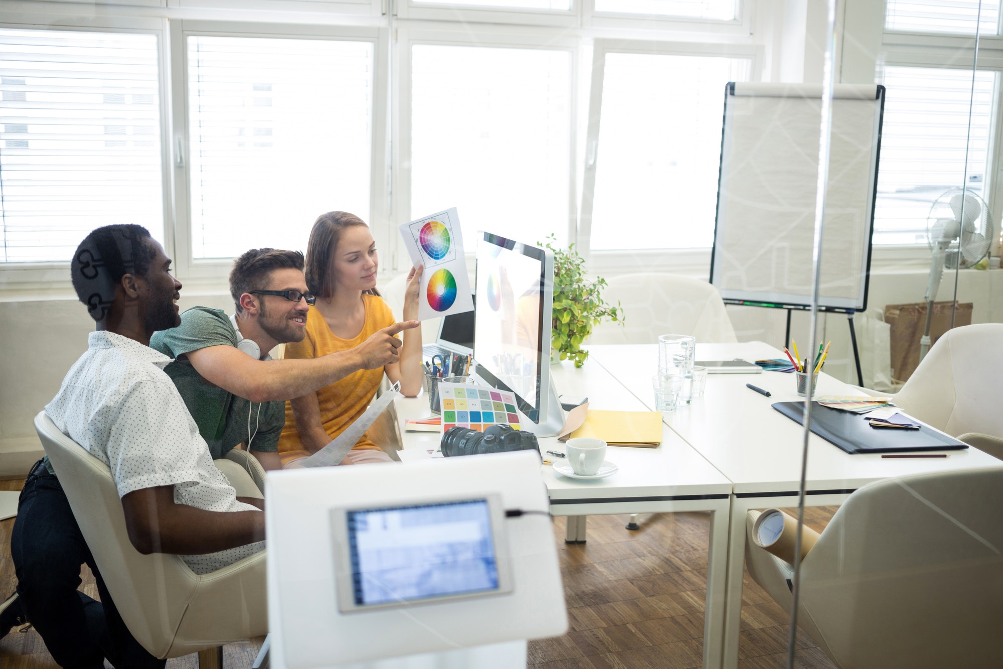 graphic designers discussing over computer at their desk