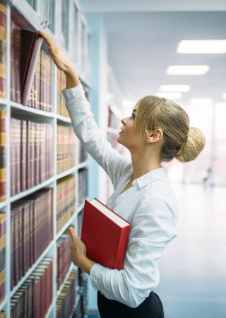 Female Student Looking Book At The Shelf Library 72Zblxj